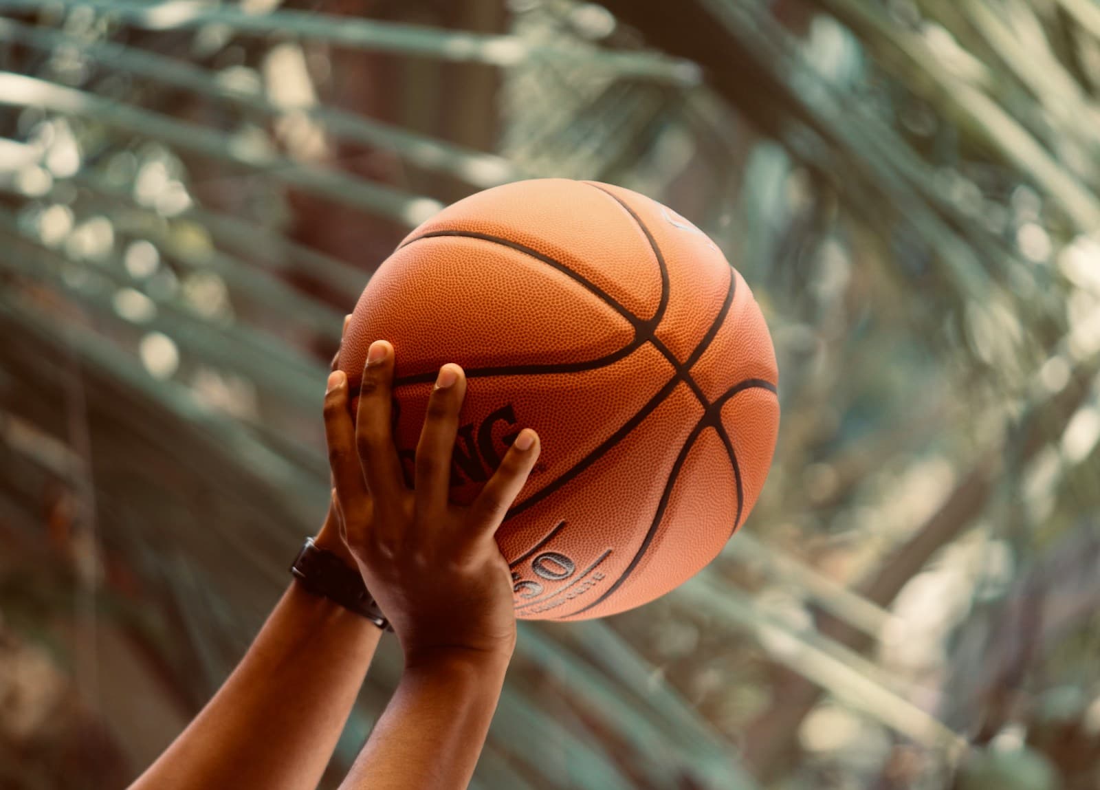 Hands lifting a basketball to shoot